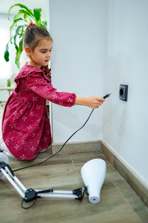 Young girl engages with a charging station in a bright indoor setting while exploring technology