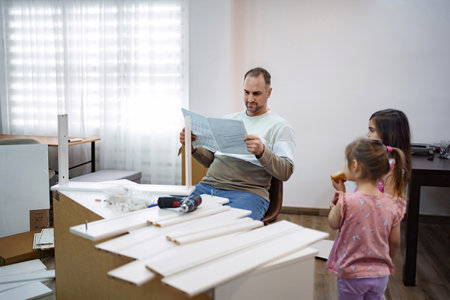 Father and daughters enjoy a DIY project at home on a weekendの写真素材