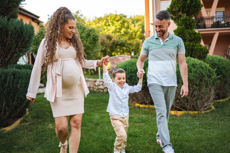 Joyful family stroll in a lush garden during golden hourの写真素材