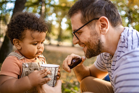 Enjoying a cozy moment in the park with a toddler on a sunny dayの写真素材