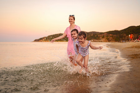 Joyful family moments splashing near the shore at sunsetの写真素材