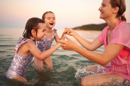 Joyful moments at the water with family during sunset at the beachの写真素材