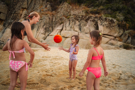 Fun family moments playing ball on a sunny beach dayの写真素材