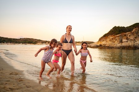 Joyful family bonding at the beach during sunsetの写真素材