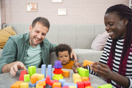 Family engaging in playtime with colorful building blocks indoorsの写真素材
