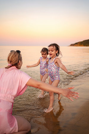 Joyful family moments at the beach during sunset skyの写真素材