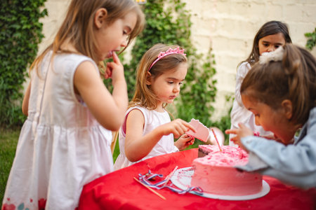 Girls celebrating with cake outsideの写真素材