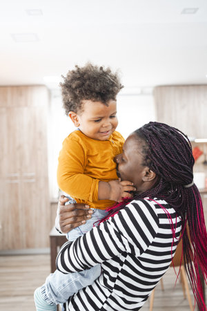 Multiracial family enjoying playful moments indoors with toddlerの写真素材