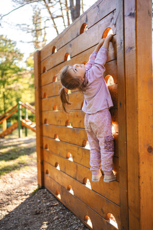 Little cute girl is climbing on the playgroundの写真素材