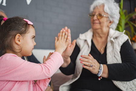Joyful clapping game with grandma and granddaughterの写真素材