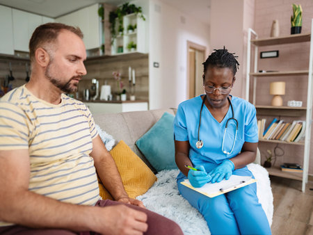 Nurse engages with patient in a cozy home settingの写真素材