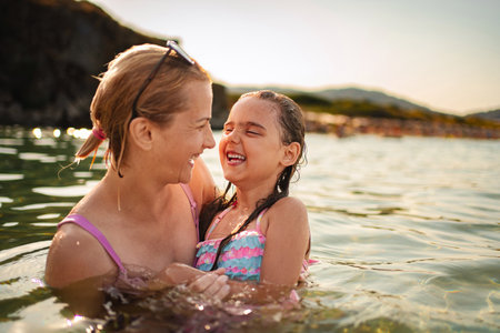 Memorable moments of joy between mother and daughter at the beachの写真素材