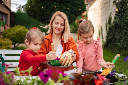 Mother and daughters happily cultivate plants in garden