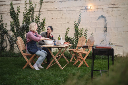 Friends enjoying a barbecue in a cozy garden at sunset