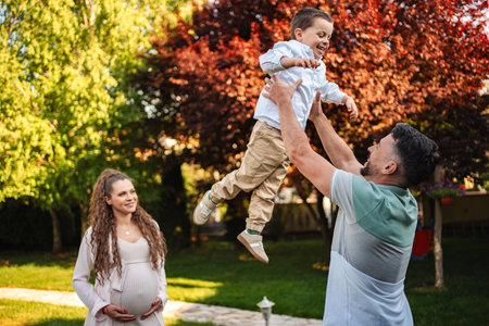 Joyful family moment under blooming trees in springtimeの写真素材