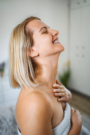 Mid adult woman taking care of her skin after shower
