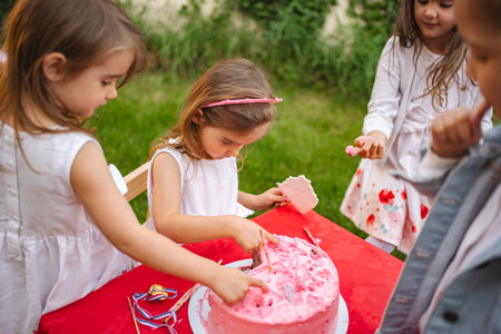 Children celebrating with a fun cake cutting activityの写真素材