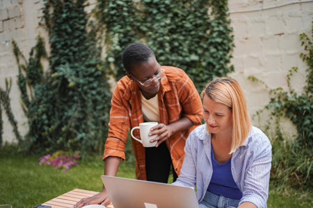 Two businesswomen collaborating on a project in a garden