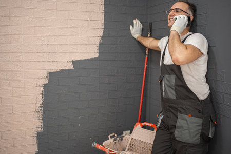 Man in Overalls Talking on a Cell Phoneの写真素材