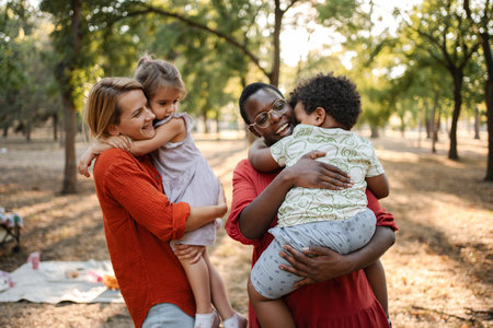 Mothers hugging their children in the park during a picnicの写真素材