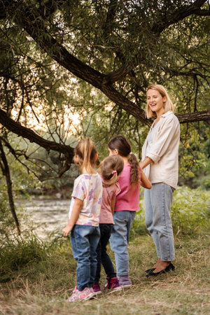 Teacher and preschool age children enjoying nature near riverの写真素材