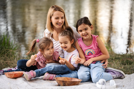 Happy family enjoying a picnic by the lakeの写真素材