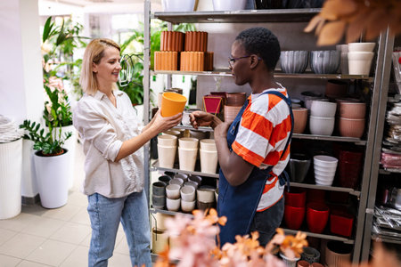 Shop assistant helping customer choosing a flower pot in a garden centerの写真素材