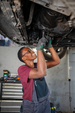 Young female mechanic repairing car in a garageの写真素材