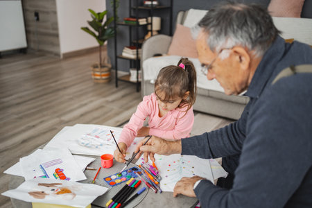 Grandpa and granddaughter share fun art projectsの写真素材