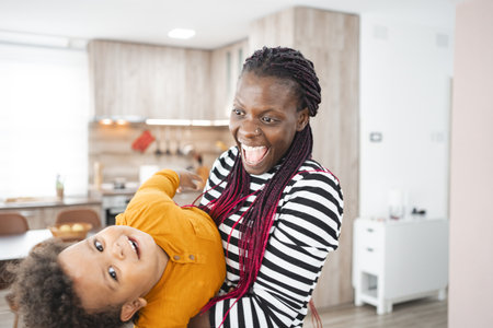 Joyful multiracial family playing together in a modern kitchenの写真素材