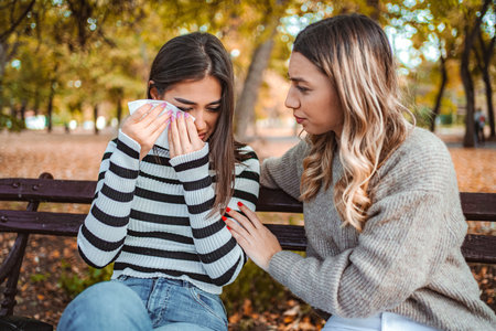 Friends share an emotional moment in a beautiful autumn park scene