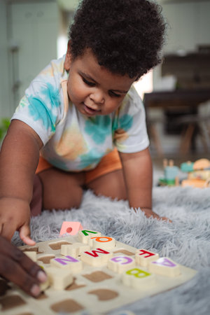 Toddler playing alphabet puzzle learning at home