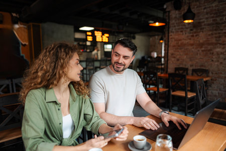 Young entrepreneurs working together on a laptop in a cafe