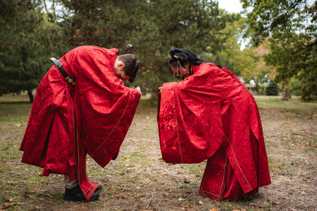 Multicultural wedding couple bowing in traditional Chinese ceremonyの写真素材