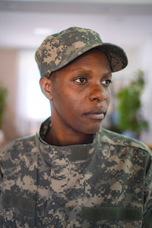 Confident african american female soldier looking away wearing camouflage uniform