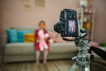 Capturing joyful moments of a child holding a stuffed animal in a cozy living room during a family gatheringの写真素材