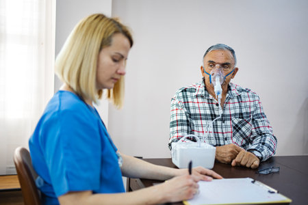 Caregiver assisting older man with respiratory therapy