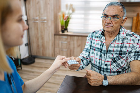 Elderly man gets meds in a cozy roomの写真素材