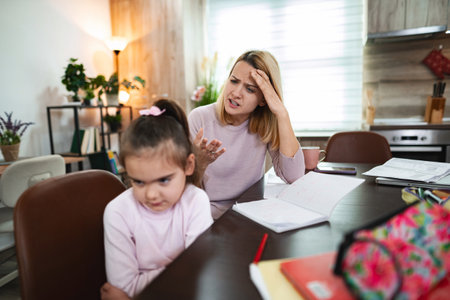 Conflict between parent and child during home study time in cozy kitchenの写真素材