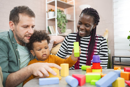 Multiracial family plays with colorful building blocks at homeの写真素材