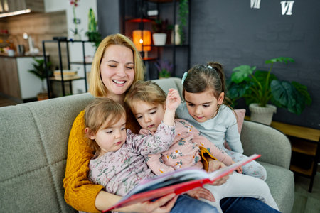 Mother looks at a book and reads a story to her daughters