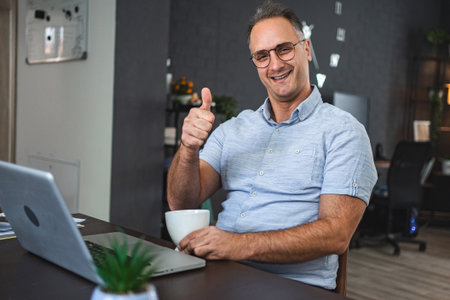 Middle aged Caucasian man working on laptop at homeの写真素材
