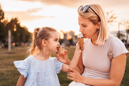 Happy family enjoying ice cream cones outdoorsの写真素材