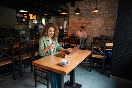 Freelancer is working at cafe using laptop and smartphoneの写真素材