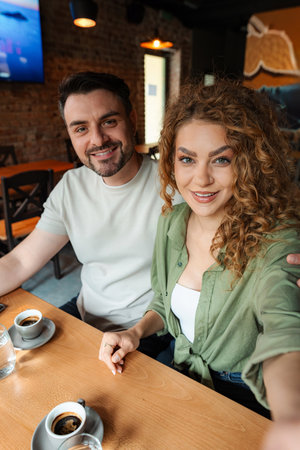 Young couple taking a selfie while having coffee in a cafe