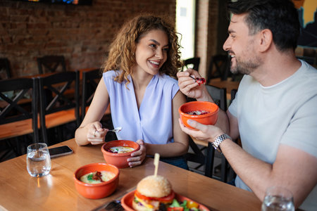 Happy couple enjoying a meal together at a restaurantの写真素材