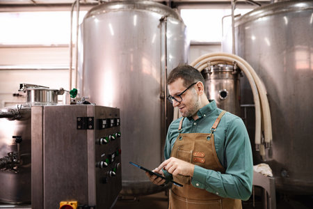 Brewery worker controlling production process using digital tablet