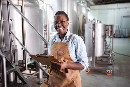 Woman brewmaster checking quality in craft beer breweryの写真素材