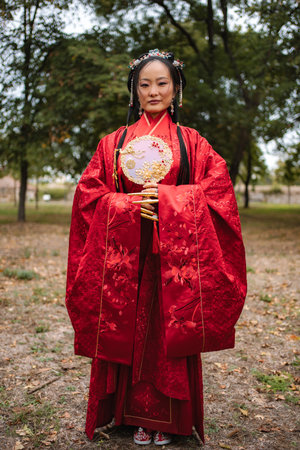 Chinese bride wearing traditional red wedding dress in natureの写真素材