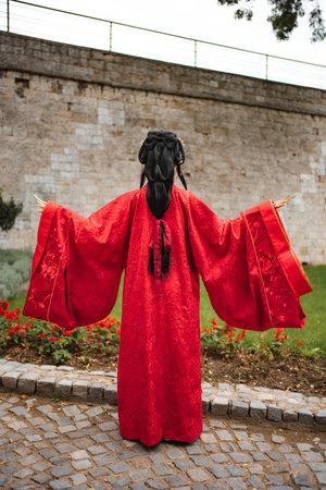 Chinese bride wearing traditional red wedding dress in gardenの写真素材
